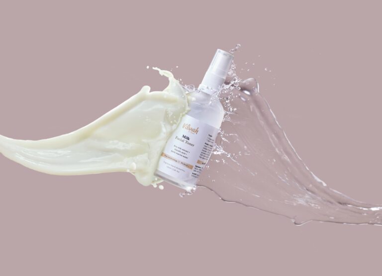 High-speed capture of milk and water splashing around a facial toner bottle, highlighting skincare product.